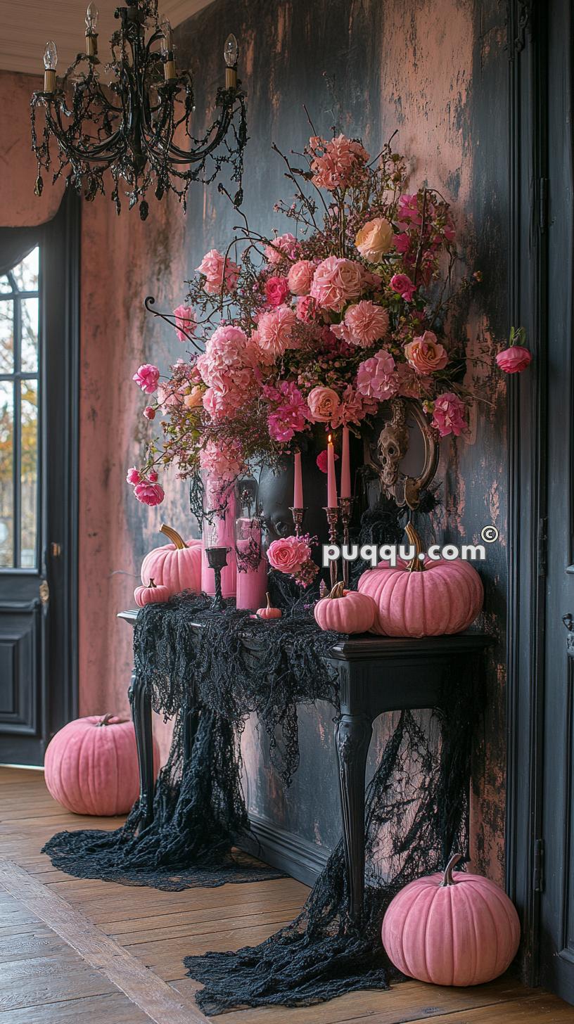 Elegant gothic-style interior with pink pumpkins, black lace, a bouquet of pink flowers on a table, pink candles, and a black chandelier.