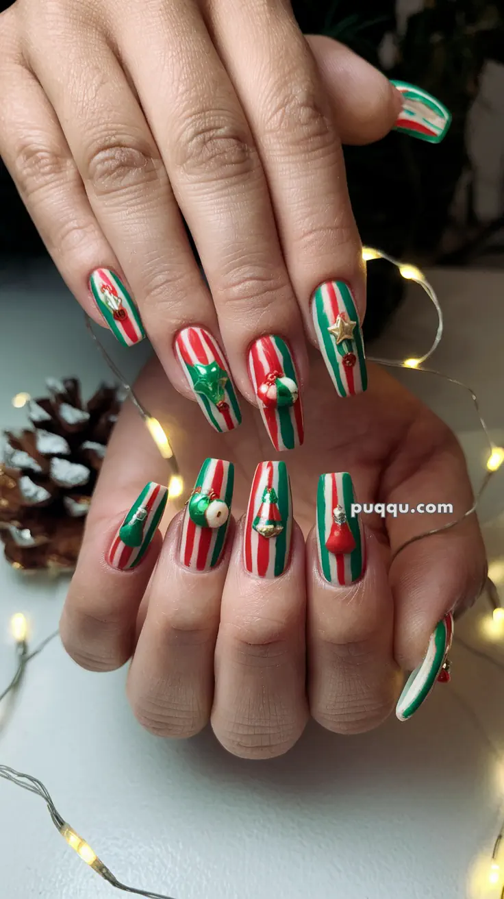 Hands with festive striped nail art in red, white, and green, featuring Christmas-themed decorations like stars and bells.