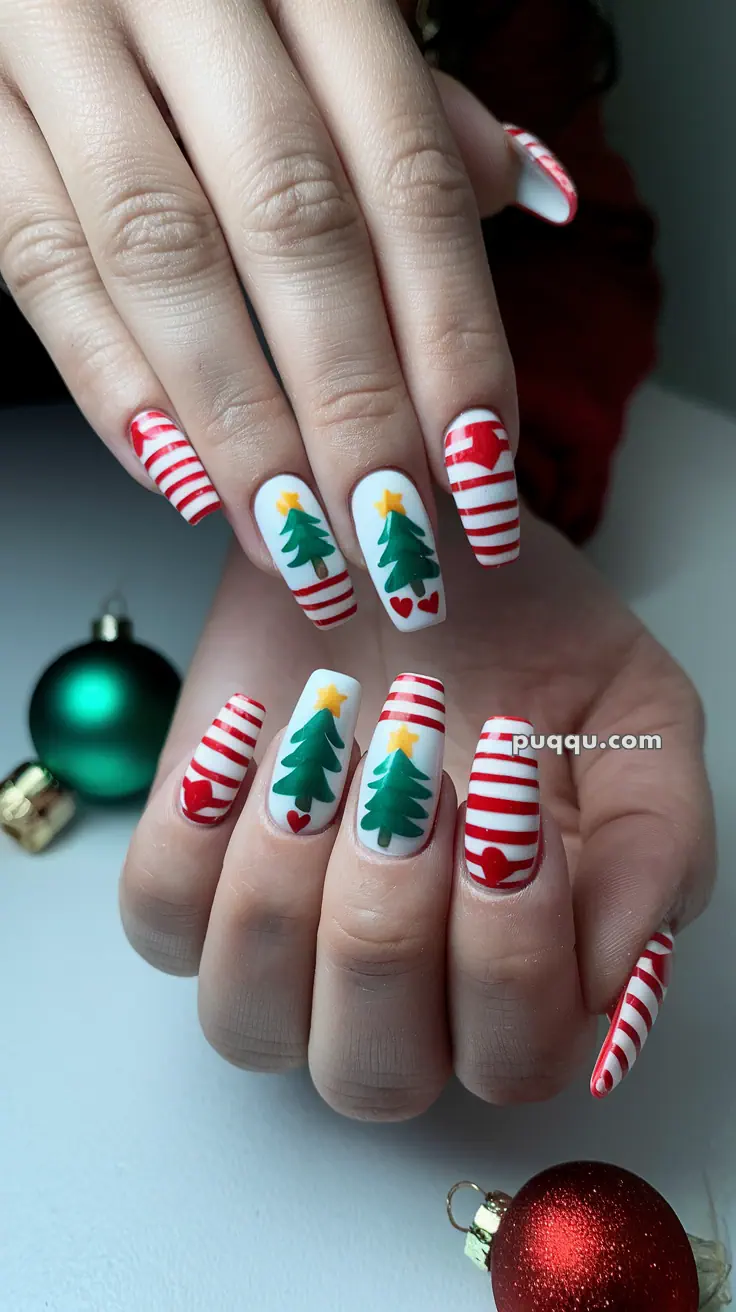Close-up of hands with festive nail art featuring Christmas trees, stars, hearts, and red stripes.