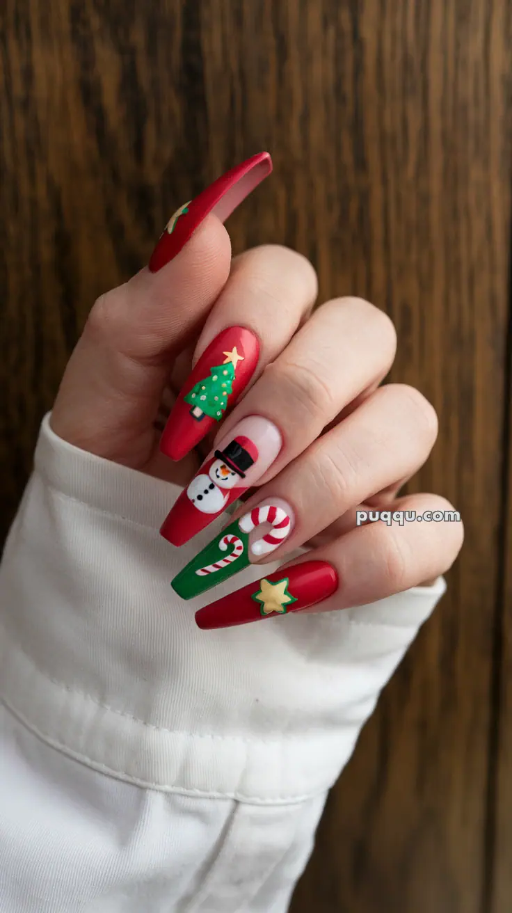 Hand with festive nail art featuring a snowman, Christmas tree, candy cane, and stars on red and green nails.
