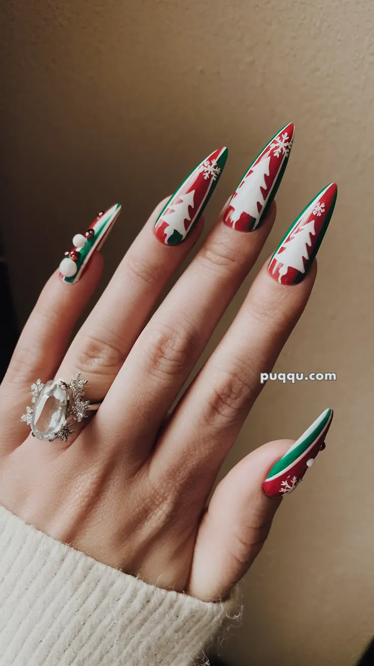 Festive Christmas-themed nails with white trees and snowflakes on red and green backgrounds, adorned with a large silver and crystal ring.