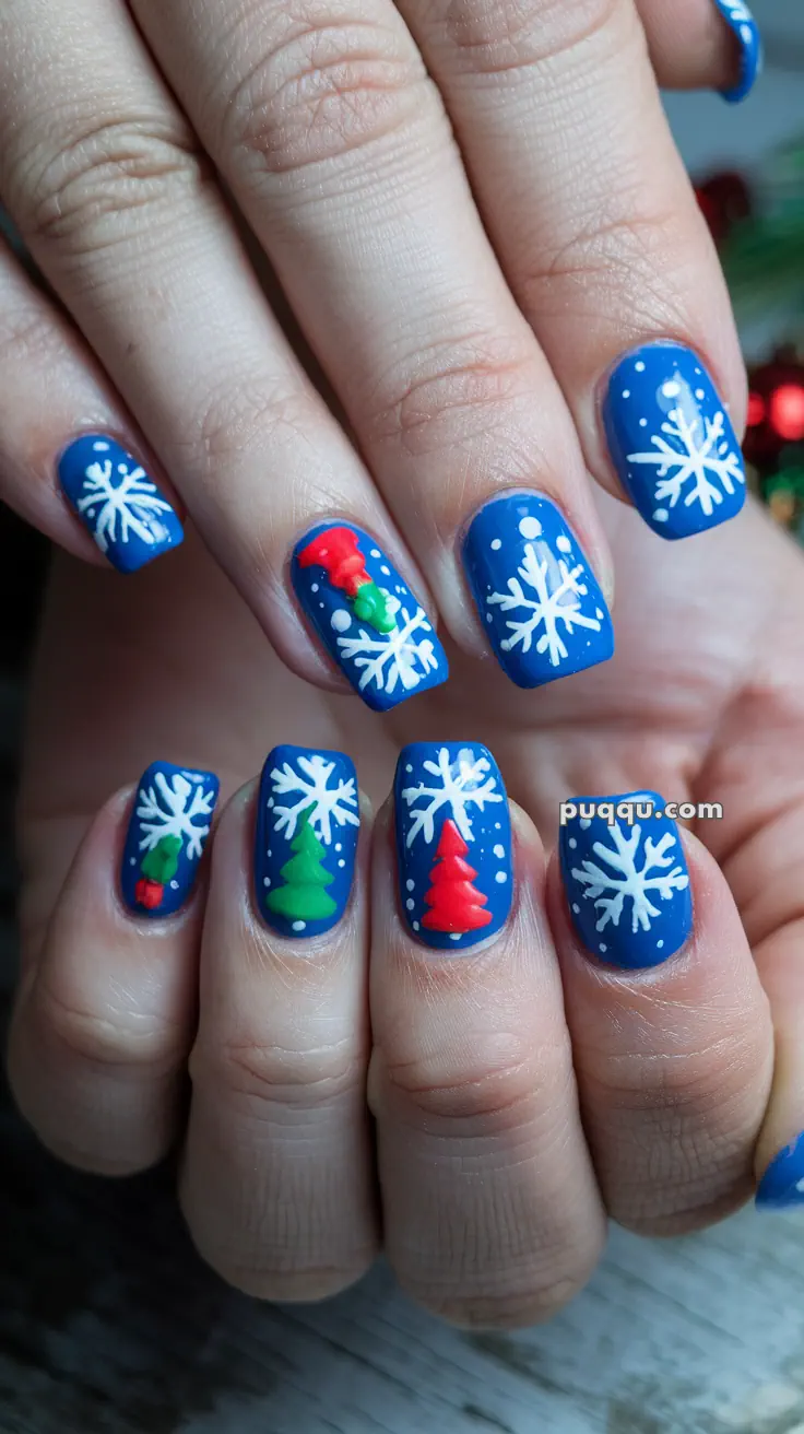 Blue nails with white snowflakes and red and green Christmas tree designs.