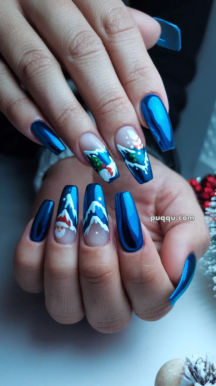 Hands with long, blue metallic nails featuring holiday-themed designs including Santa, Christmas trees, and snowy mountains.