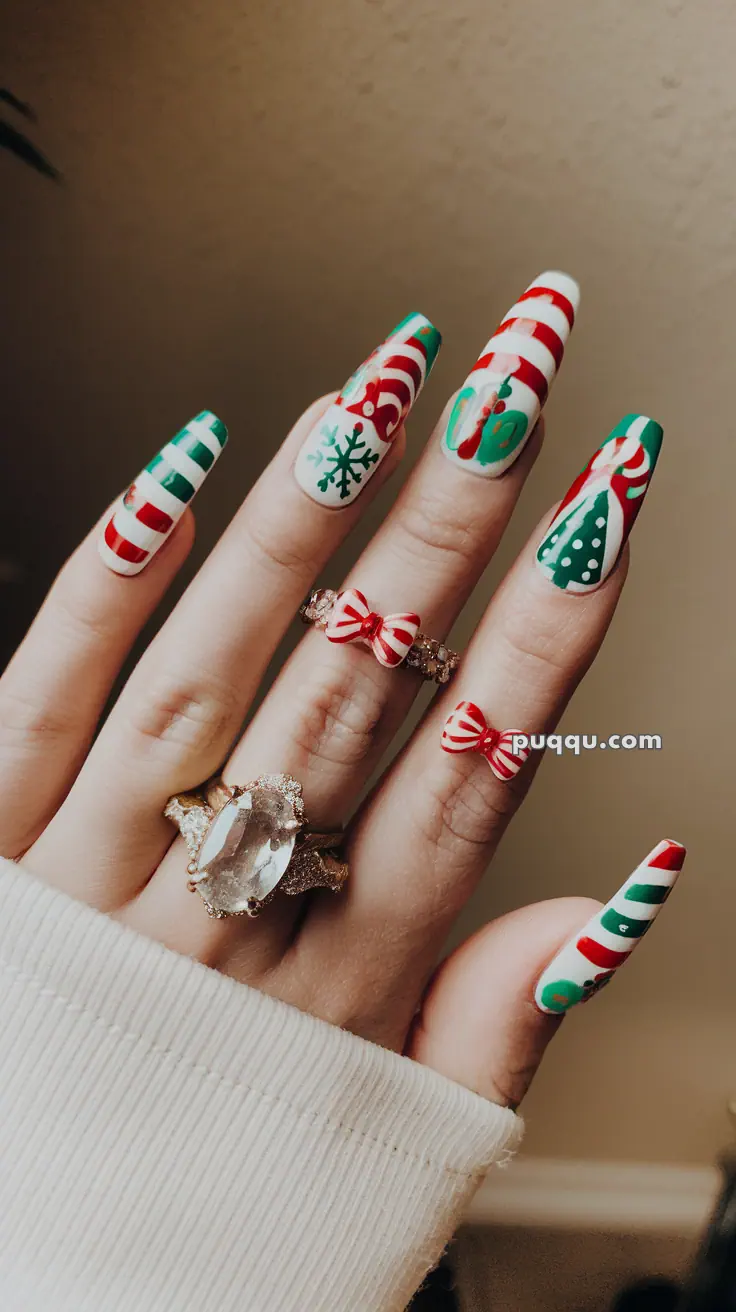 Hand with festive Christmas-themed nail art and decorative rings, including a large gemstone and a red bow.