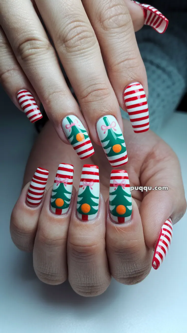 Fingernails with Christmas-themed nail art, featuring red and white stripes, green trees, and orange ornaments.