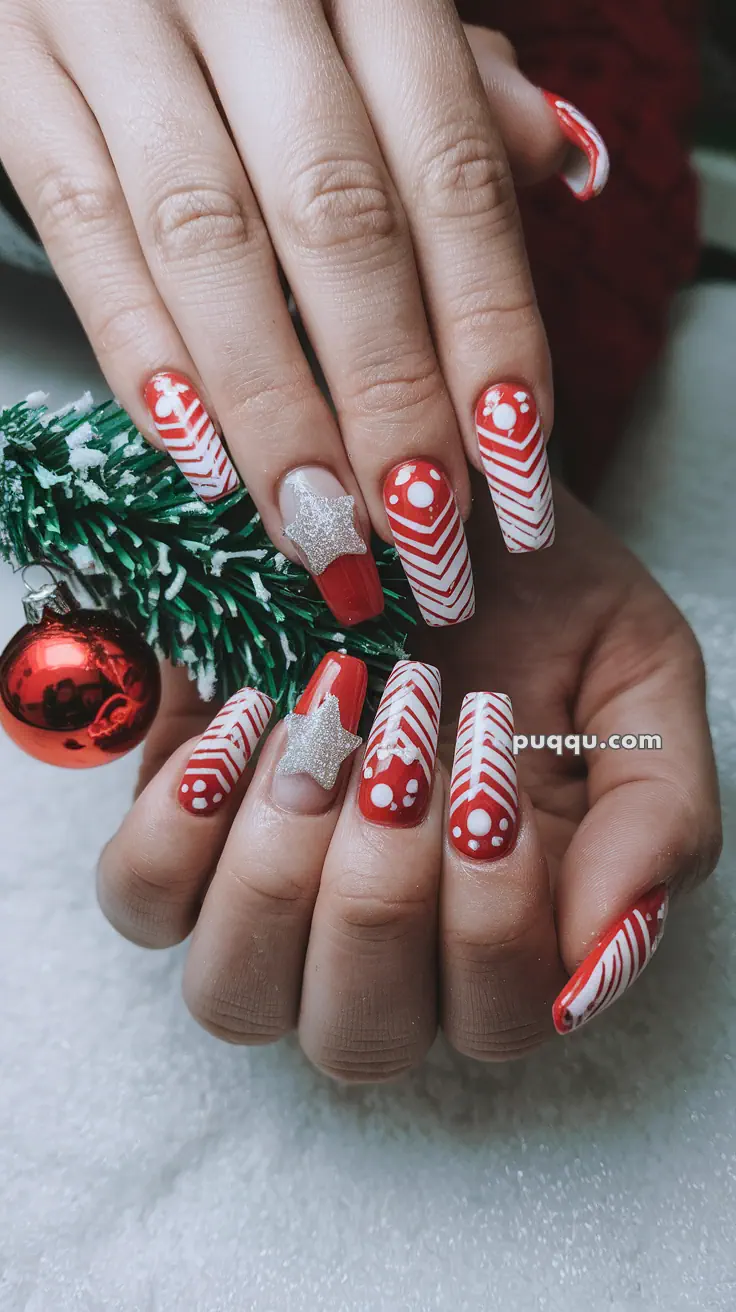 Festive red and white holiday-themed nail art with silver star accents, featuring stripes and polka dots.