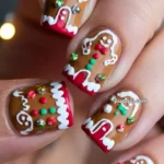 Close-up of festive nail art featuring gingerbread men designs with colorful accents and detailing.